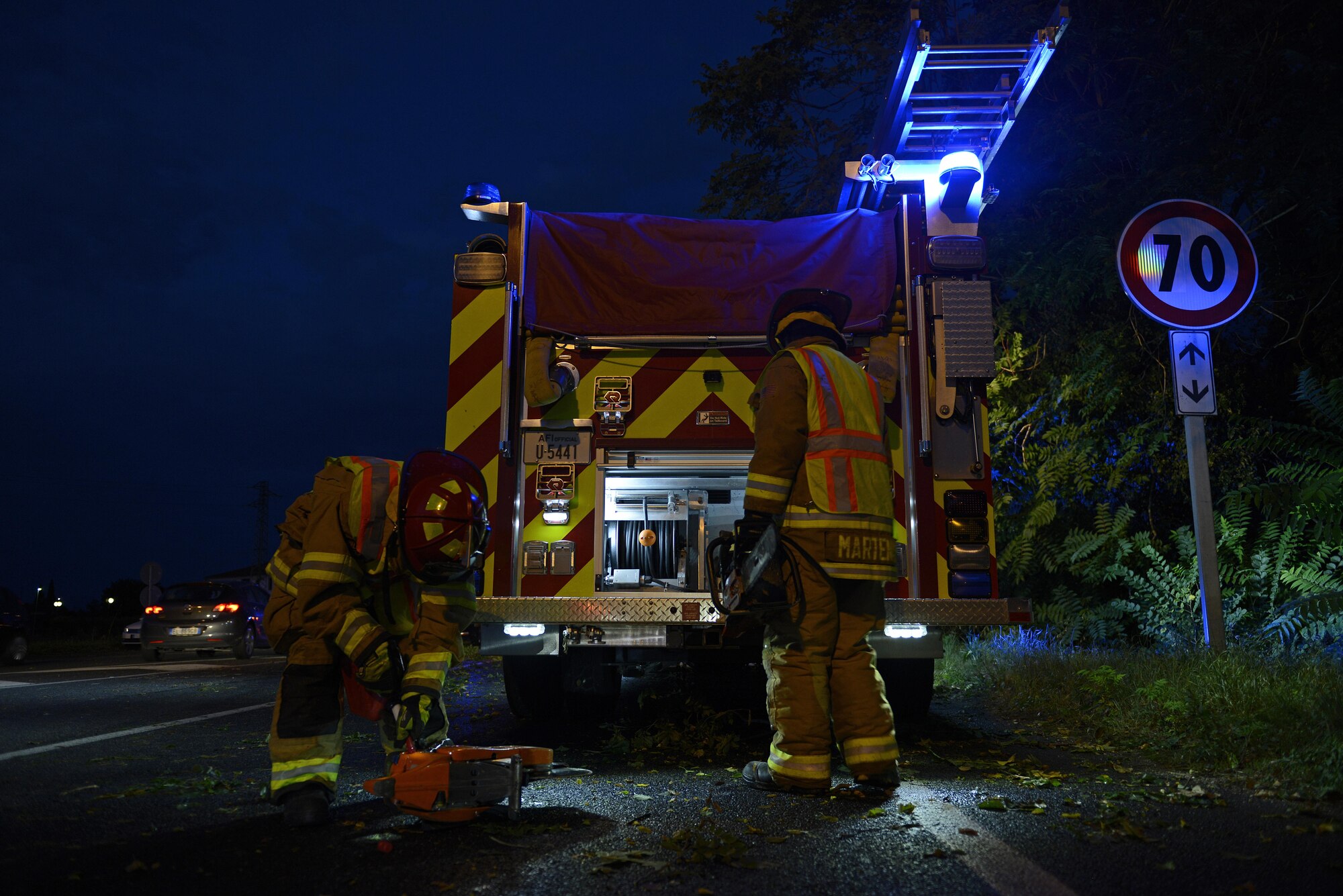 Staff Sgt. Jason Holmes and Tech. Sgt. Brian Martenis, 31st Civil Engineer Squadron firefighters, prepare to remove a tree from a highway Aug. 10, 2017, in Pordenone, Italy. The 31st CES firefighters teamed with local first responders to clear roadways after heavy thunderstorms passed through the area. (U.S. Air Force photo by Tech. Sgt. Andrew Satran)