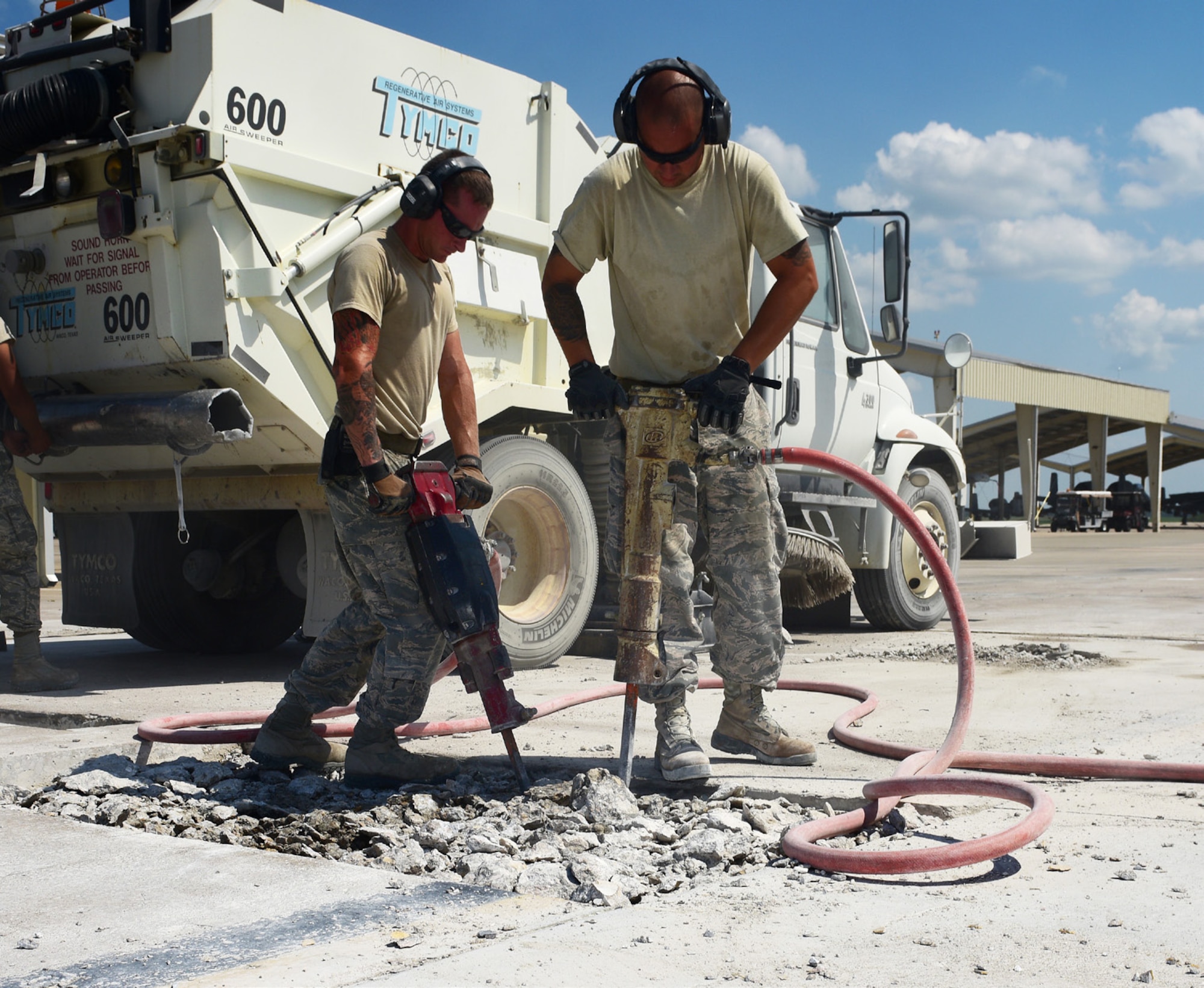 U.S. Air Force Staff Sgt. Dozzi, left, and Staff Sgt. Warkocz, 509th Civil Engineer Squadron pavement and equipment shop supervisors, use jack hammers to break cement apart on the flightline at Whiteman Air Force Base, Mo., July 25, 2017. First, the Dirtboyz cut sections of spalled concrete with a K-12 concrete saw then jack hammer the ground to break it into small enough pieces for the airfield sweeper to remove the debris.