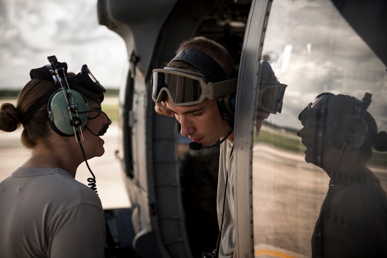 Airmen talking in prepping HH-60G Pave Hawk for flight.