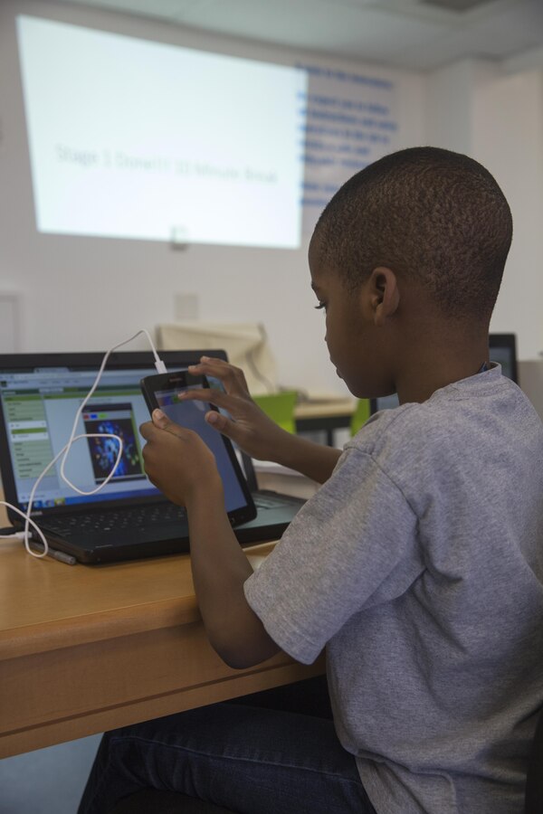 Michael Adeniyi, student, Maker Space Lab, transfers a photo to his mobile device at the Shadow Mountain Branch Library aboard the Marine Corps Air Ground Combat Center, Twentynine Palms, Calif., August 9, 2017. The library conducted the lab to foster excitement about the future of technology in children from military parents and open their minds to positive opportunities. (U.S. Marine Corps photo by Pfc. Margaret Gale)