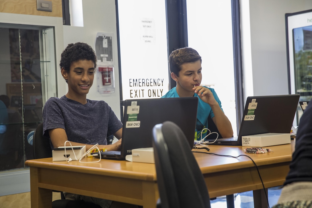 Jayden Pena and Bryce Gussman, students, Maker Space Lab, conduct research for the development of a meme at Shadow Mountain Branch Library aboard the Marine Corps Air Ground Combat Center, Twentynine Palms, Calif., August 9, 2017. The library conducted the lab to foster excitement about the future of technology in children from military parents and open their minds to positive opportunities. (U.S. Marine Corps photo by Pfc. Margaret Gale)
