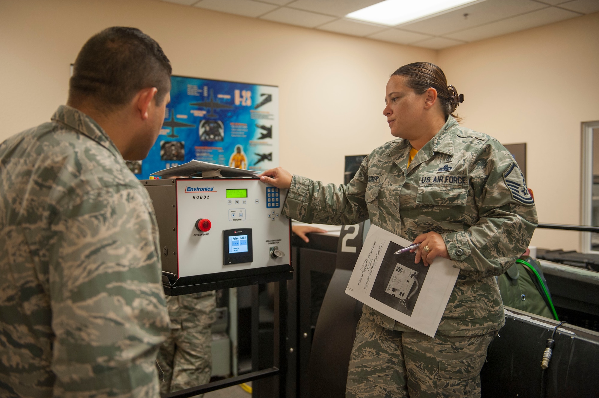Master Sgt. Jennifer Flecker, 9th Physiological Support Squadron support flight chief, runs through the initial process of turning on and preparing a Reduced Oxygen Breathing Device for a hypoxia demonstration.