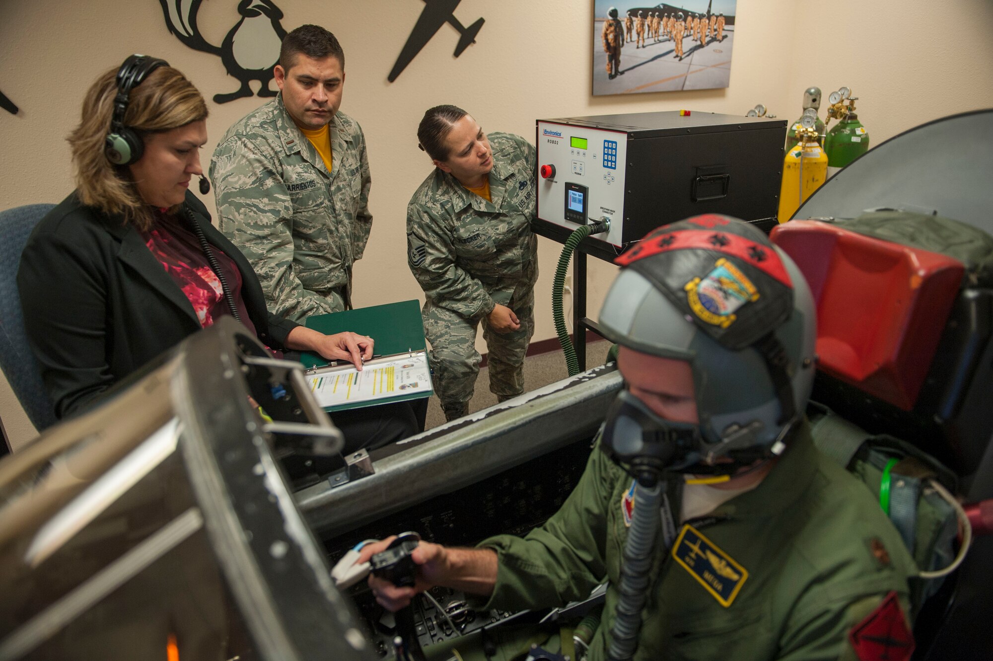 9th Physiological Support Squadron personnel monitor a pilot's vitals and cognitive abilities as he flies a simulated mission using the Reduced Oxygen Breathing Device.