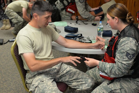 U.S Air National Guard Staff Sgt. Amanda Harriman, Medical Technition, CERFP Medical Response Team, assigned to the 157th Medical Group at Pease Air National Guard Base, N.H. completes a pre-entry vitals check on U.S. Army Staff Sgt. Joe Spinelli, CERFP search and extraction team member, assigned to the 861st Engineer Company, R.I. National Guard, during the notional mass casualty CERFP New England Exercise held at Fort Indiantown Gap, Pa. (U.S. Air National Guard photo by Master Sgt. Thomas Johnson)