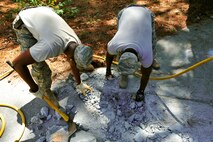U.S. Airmen assigned to the 20th Civil Engineer Squadron worked as a team to demolish an uneven concrete sidewalk upheaved by tree roots at Shaw Air Force Base, S.C., Aug. 10, 2017. The pavement and construction equipment Airmen,  also known as “Dirt Boyz,” used tools such as a pneumatic 30-pound jack hammer and pickaxe to remove approximately five cubic yards of concrete to make way for a new path. (U.S. Air Force photos by Airman 1st Class Kathryn R.C. Reaves)