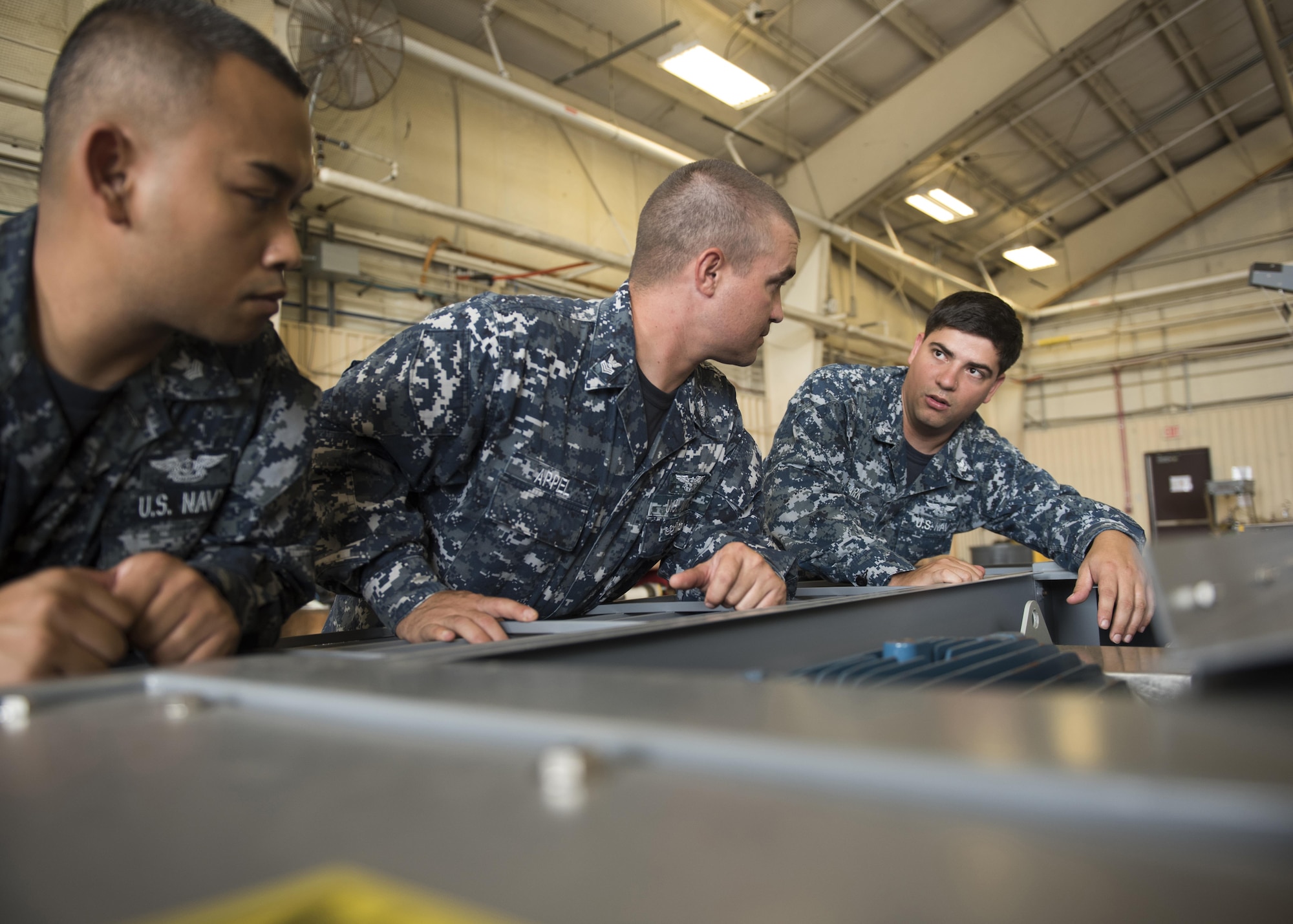 U.S. Navy Aviation Support Equipment Technician Second Class Eric Stark, 33rd Maintenance Squadron Aerospace Ground Equipment, discusses some of the features of an electric conditioned air cart with Aviation Support Equipment Technicians First Class Kunthea Sam, left, and Jerimiah Appel, center, both assigned to the USS Abraham Lincoln (CVN-72), during "Phase 1" initial training Aug. 9, 2017, at Eglin Air Force Base, Fla. Because many of the machines used to support the F-35 are unique to the aircraft, this is the first time they are seeing the equipment. They will use what they learn here when F-35Cs land on their ship and to train other maintainers in their unit. (U.S. Air Force photo by Staff Sgt. Peter Thompson)