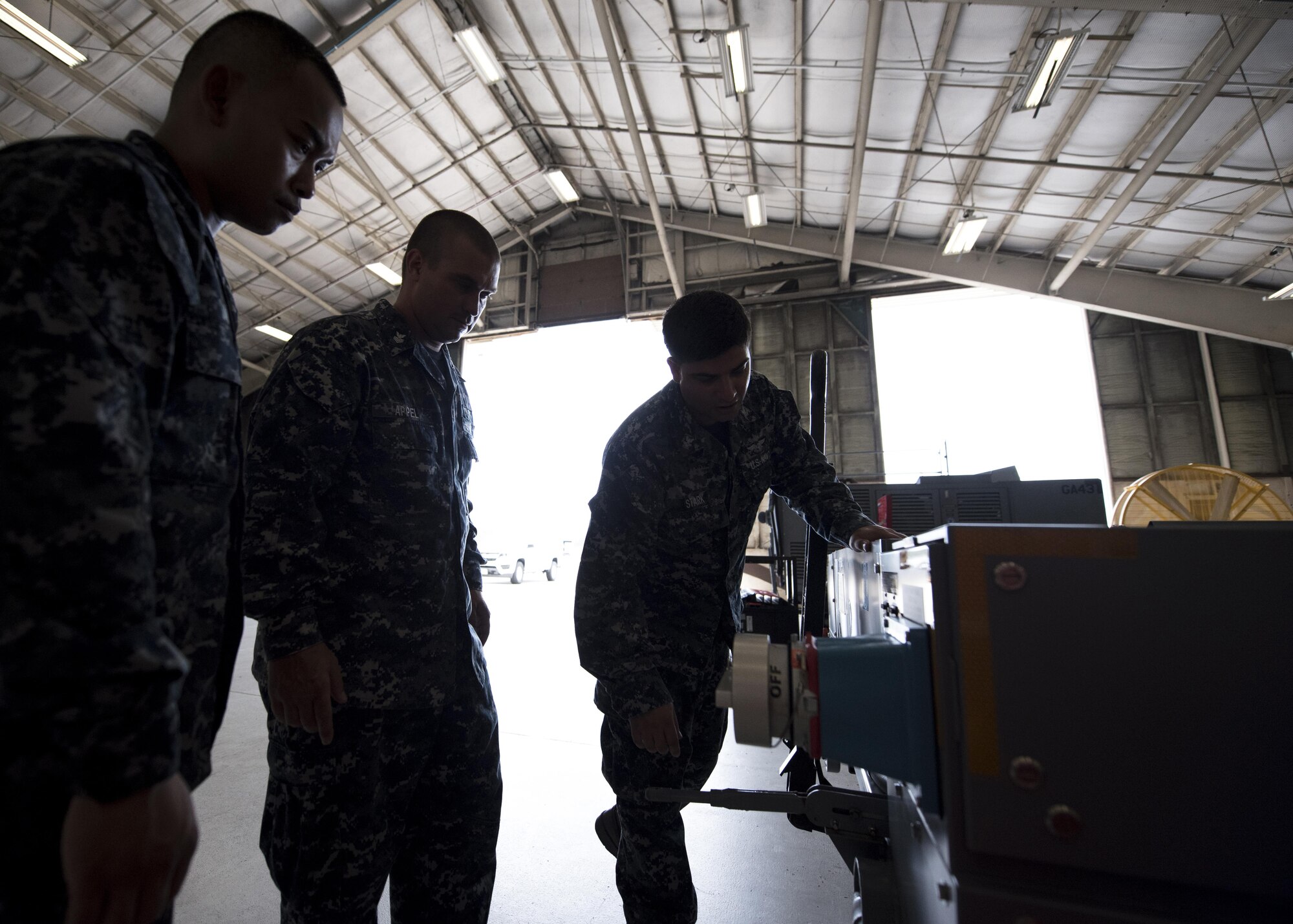U.S. Navy Aviation Support Equipment Technician Second Class Eric Stark, right, 33rd Maintenance Squadron Aerospace Ground Equipment, discusses some of the features of an electric conditioned air cart with Aviation Support Equipment Technicians First Class Kunthea Sam, left, and Jerimiah Appel, center, both assigned to the USS Abraham Lincoln (CVN-72), during "Phase 1" initial training Aug. 9, 2017, at Eglin Air Force Base, Fla. Because many of the machines used to support the F-35 are unique to the aircraft, this is the first time they are seeing the equipment. They will use what they learn here when F-35Cs land on their ship and to train other maintainers in their unit. (U.S. Air Force photo by Staff Sgt. Peter Thompson)