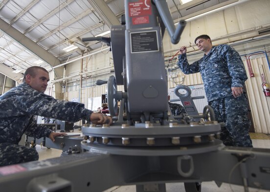 Second Class Eric Stark, right, a Navy Aviation Support Equipment Technician and a 33rd Maintenance Squadron Aerospace Ground Equipment trainer, demonstrates how to operate a portable floor crane for 1st Class Jerimiah Appel, a Navy Aviation Support Equipment Technician on the USS Abraham Lincoln (CVN-72), Aug. 9, 2017, at Eglin Air Force Base, Fla. Appel is one of two AS1s who are receiving "Phase 1" initial training for F-35 support systems from the 33rd MXS. (U.S. Air Force photo/Staff Sgt. Peter Thompson)