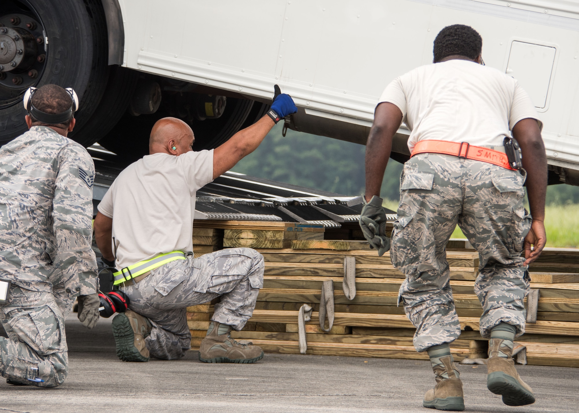 An aerial porter gives a thumbs up to the driver of a bus as it’s backed onto the cargo bay of a C-17 Globemaster III at Dobbins Air Reserve Base, Ga. Aug. 7, 2017. During the exercise, units such as the aerial port, were comprised of Airmen from different units around Air Force Reserve Command to simulate a workforce that might be expected in a deployed environment. (U.S. Air Force photo/Staff Sgt. Andrew Park)