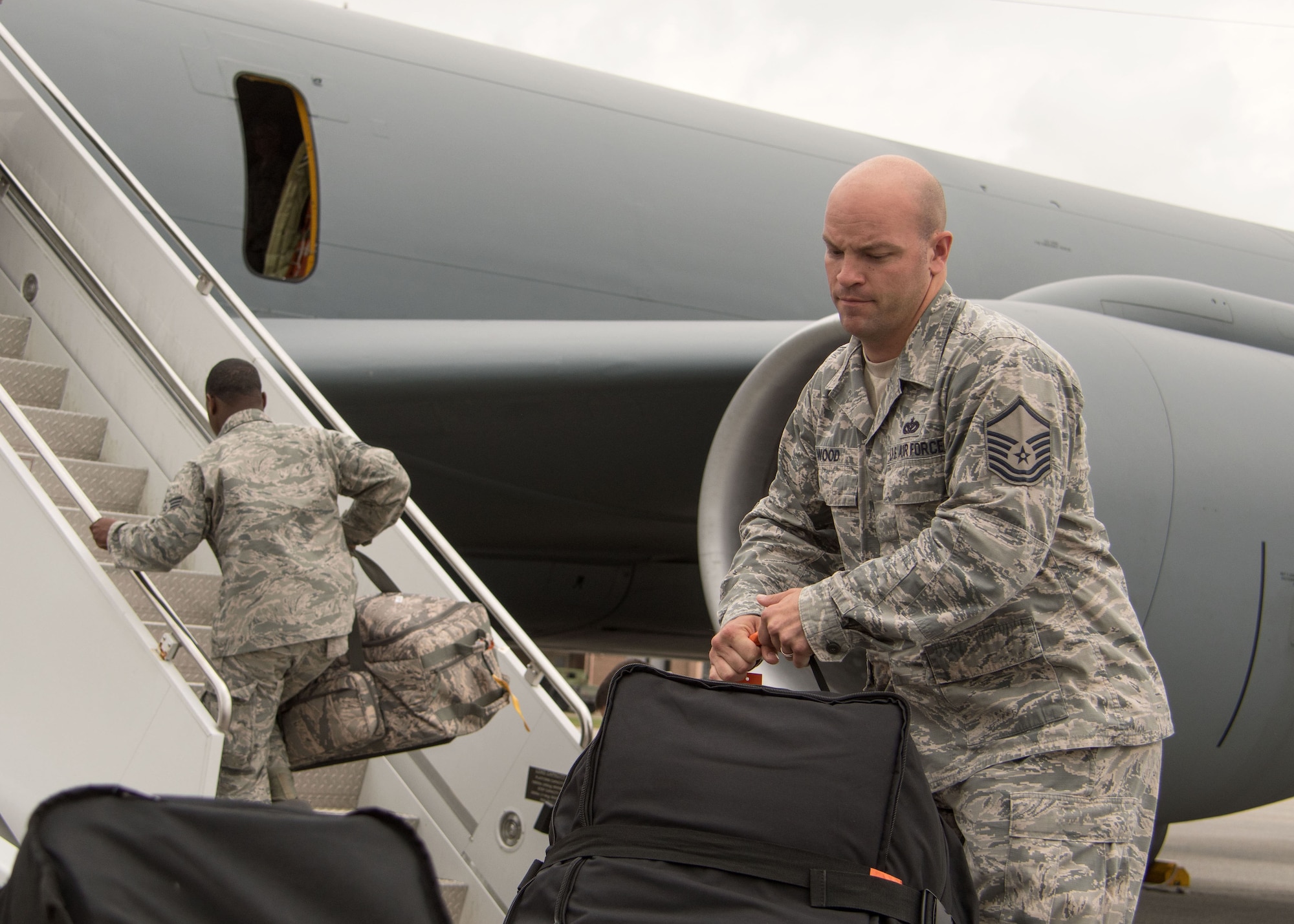 A Patriot Warrior exercise participant grabs a piece of luggage from the flightline before carrying it onto a KC-135 Stratotanker Aug. 7, 2017. The Stratotanker is from Seymour Johnson Air Force Base, N.C. (U.S. Air Force photo/Staff Sgt. Andrew Park)