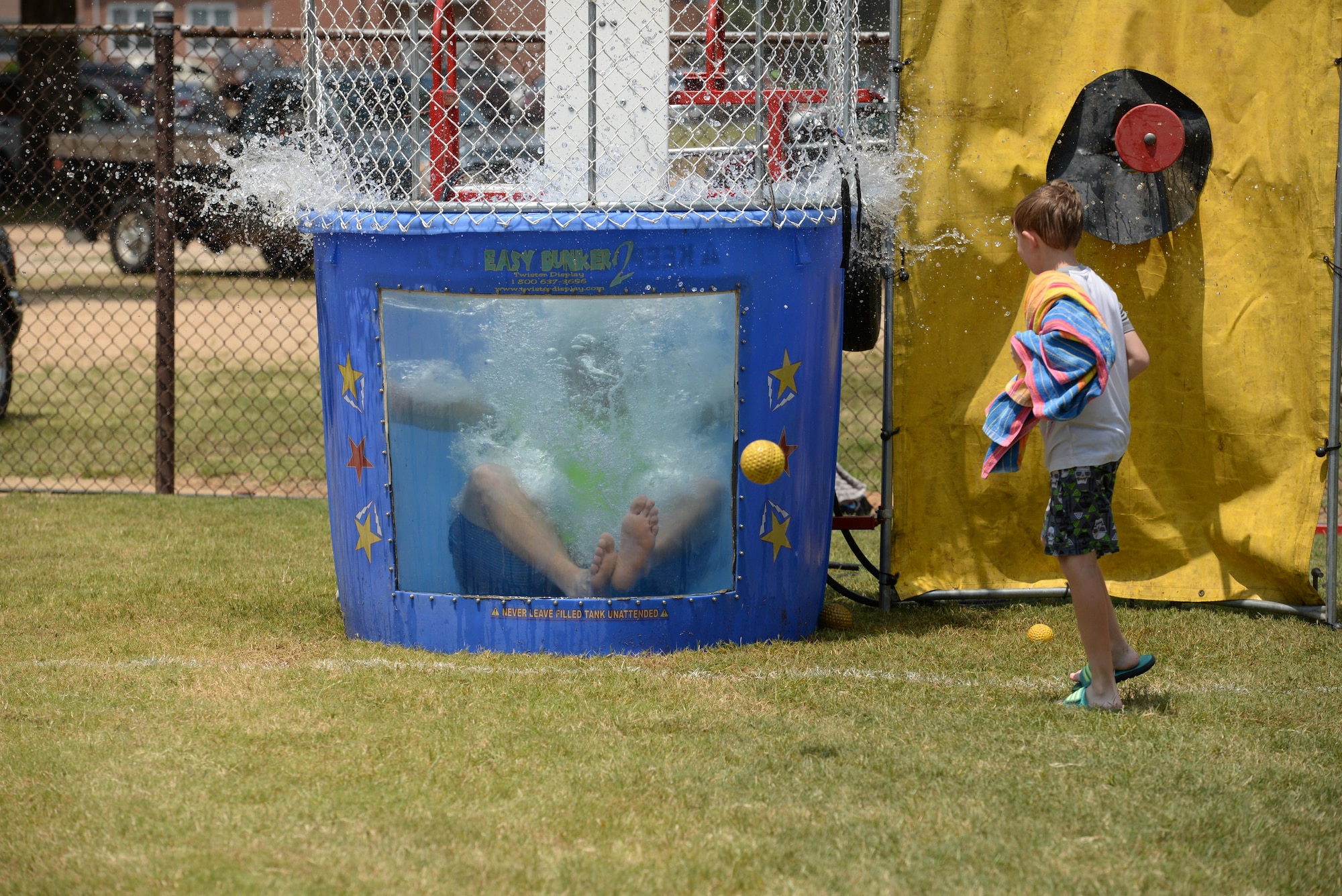 Airman 1st Class Spencer Hurlburt, 14th Operations Support Squadron Airfield Systems technician, drops into the dunk tank Aug. 4, 2017, on Columbus Air Force Base, Mississippi. Face painting, multiple inflatable water slides and a dunk tank were available at the End of Summer Bash, a family friendly event on Columbus AFB. (U.S. Air Force photo by Airman 1st Class Keith Holcomb)