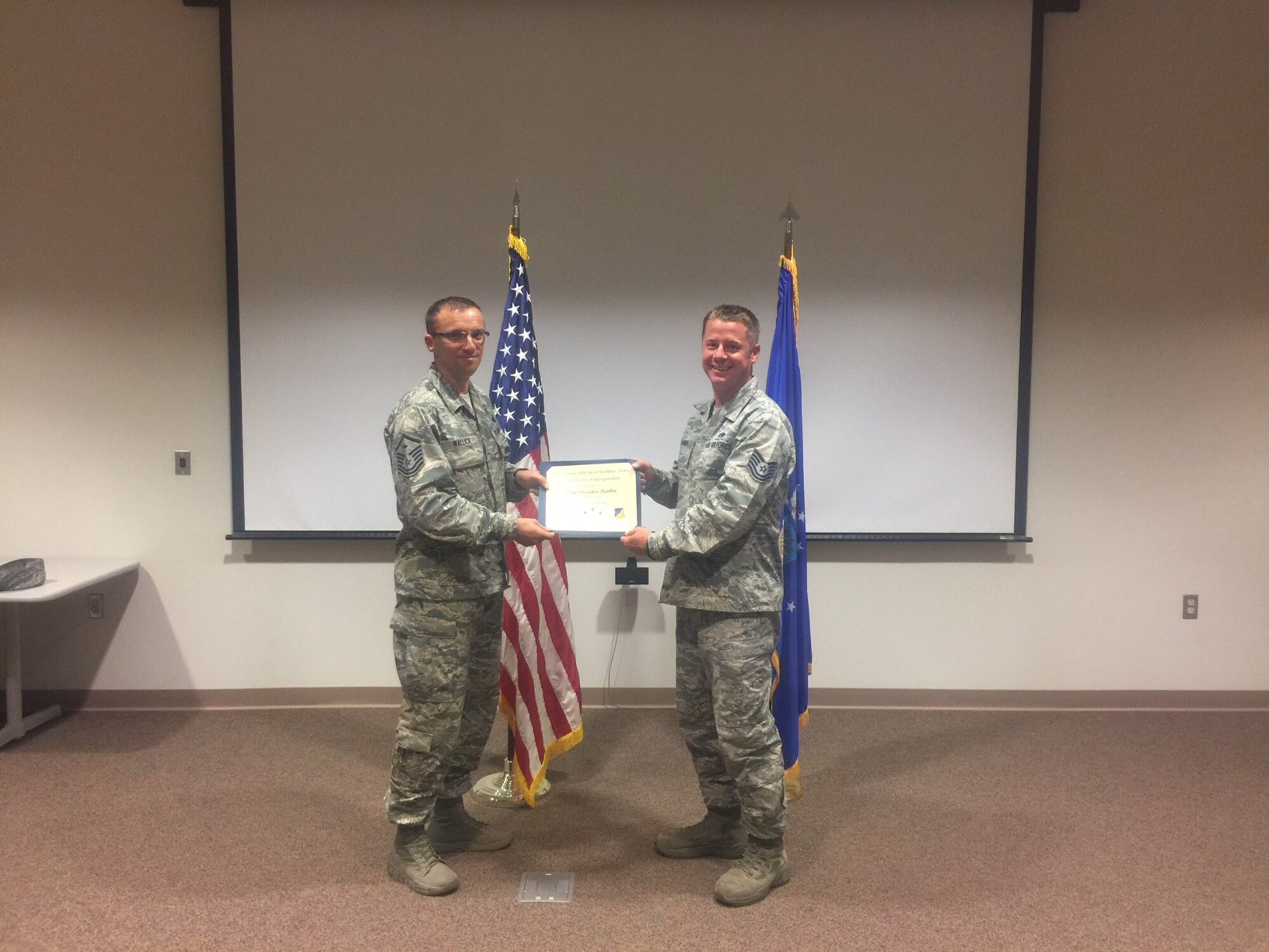 Tech. Sgt. Brandon Rankin, a 372nd Training Squadron, Detachment 10 technical training instructor, receives the June Top III noncommissioned officer award from Master Sgt. William Wallick, the 54th Aircraft Maintenance Squadron first sergeant, Aug. 2, 2017, at Holloman Air Force Base, N.M. During the month of June, Rankin accumulated 112 teaching hours over 14 days of instruction. His efforts led to the early graduation of eight students, sustaining manning requirements for six major commands. He became qualified to facilitate the new Airmanship 300 course for first term Airmen. (Courtesy photo)