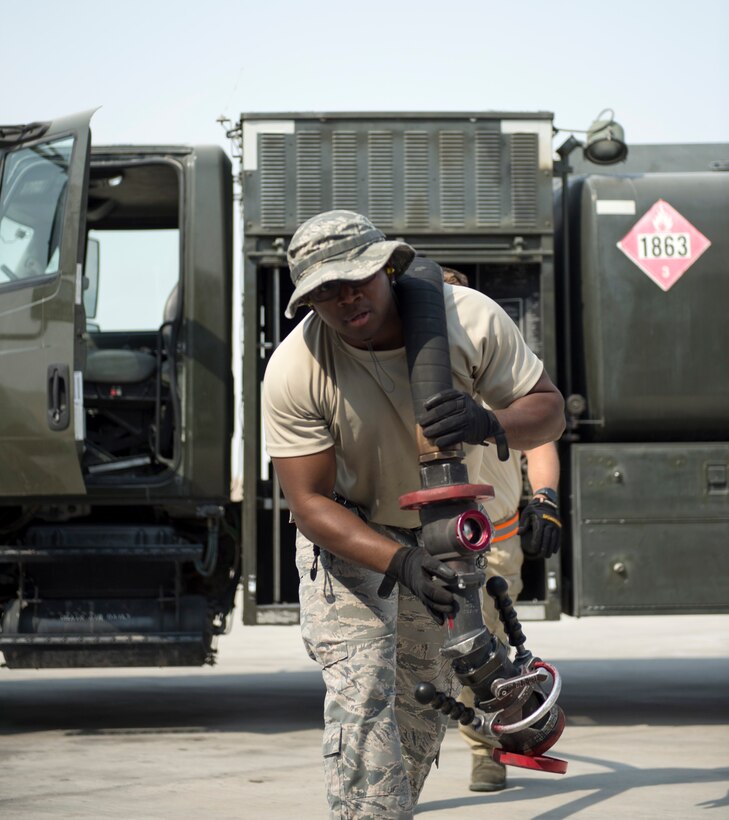 U.S Air Force Tech. Sgt. Jason Johnson, a fuels specialist with the 379th Expeditionary Logistics Readiness Squadron, Fuels Management Flight, carries a fuel hose at Al Udeid Air Base, Qatar, July 24, 2017.