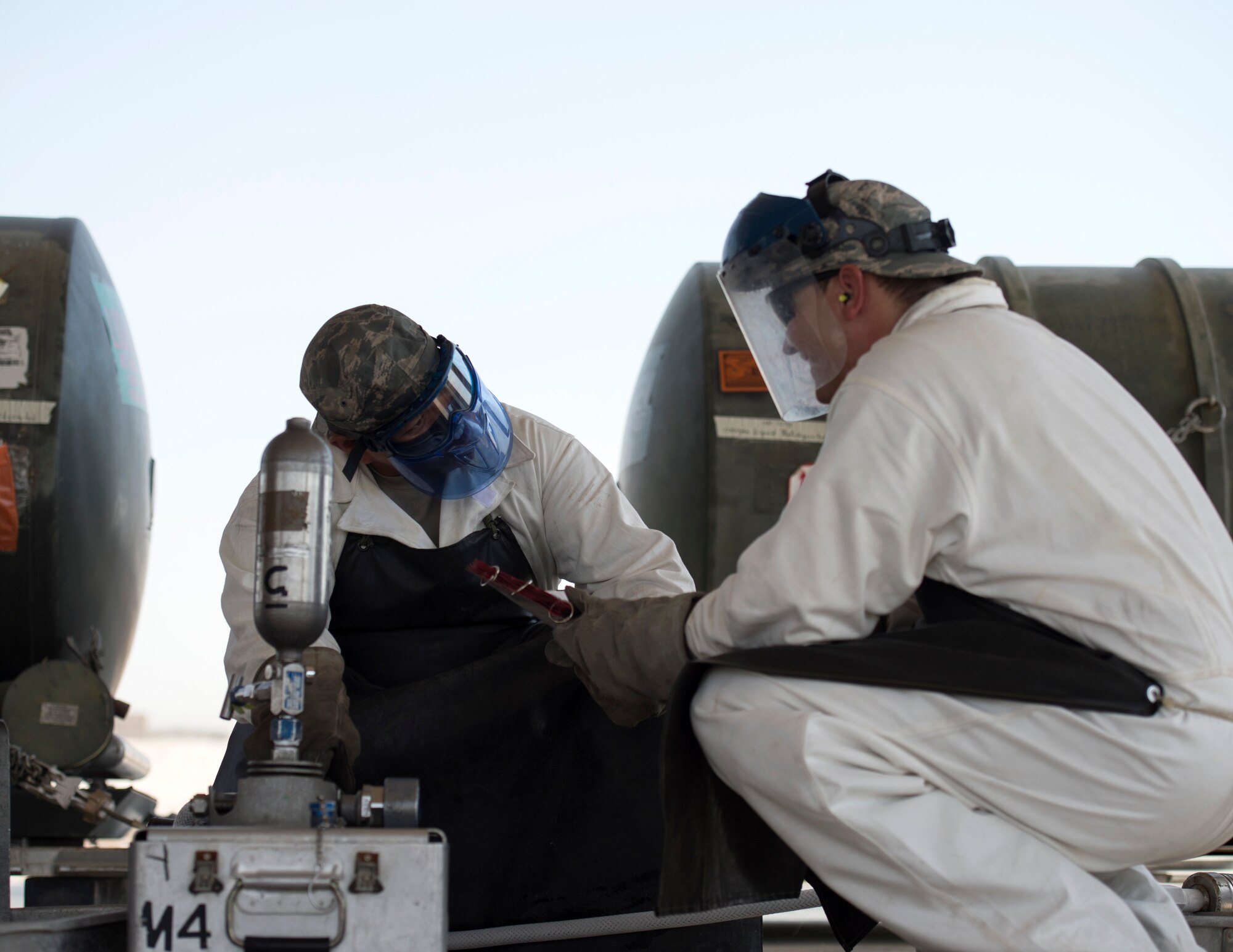 U.S. Air Force Staff Sgt. Kennie Delmo, left, a cryogenics supervisor and Senior Airman Samuel Fallot, a cryogenics journeyman with the 379th Expeditionary Logistics Readiness Squadron, Fuels Management Flight, review their checklist at Al Udeid Air Base, Qatar, Aug. 9, 2017.