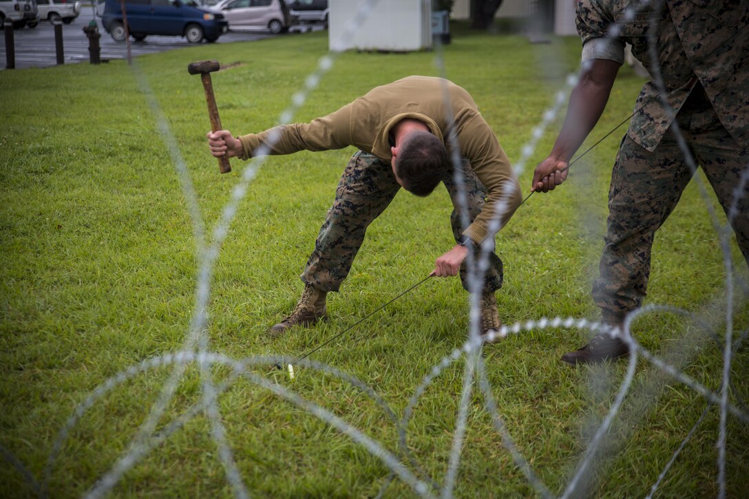 Lance Cpl. Aaron R. Smith, a data technician, hammers a tent stake into the ground at Misawa Air Base, Japan, August 10, 2017, signifying the start of exercise Northern Viper 2017. This exercise tests the interoperability and bilateral capability of the Japan Ground Self-Defense Force and U.S. Marine Corps forces to work together and provides the opportunity to conduct realistic training in an unfamiliar environment. Smith, a native of Camanche, Iowa, is with Marine Wing Communications Squadron 18, Marine Air Control Group 18, 1st Marine Aircraft Wing. (U.S. Marine Corps photo by Lance Cpl. Andy Martinez)