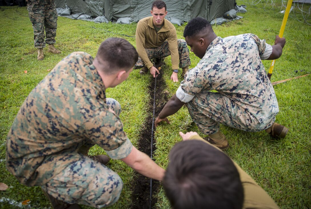 U.S. Marines with Marine Wing Communications Squadron 18 position a fiber wire on the ground at Misawa Air Base, Japan, August 10, 2017, signifying the start of exercise Northern Viper 2017. This exercise tests the interoperability and bilateral capability of the Japan Ground Self-Defense Force and U.S. Marine Corps forces to work together and provides the opportunity to conduct realistic training in an unfamiliar environment. The Marines are with MWCS-18, Marine Air Control Group 18, 1st Marine Aircraft Wing. (U.S. Marine Corps photo by Lance Cpl. Andy Martinez)