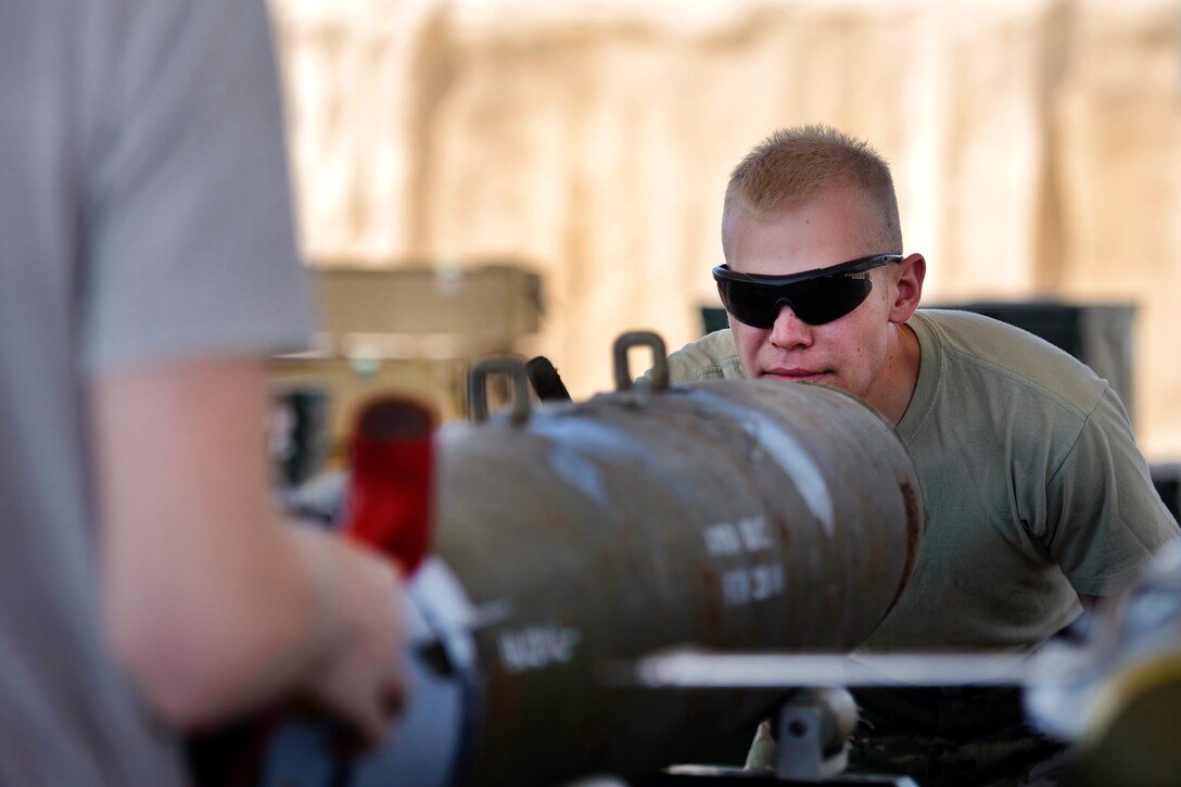 An airman aligns a guided bomb unit.