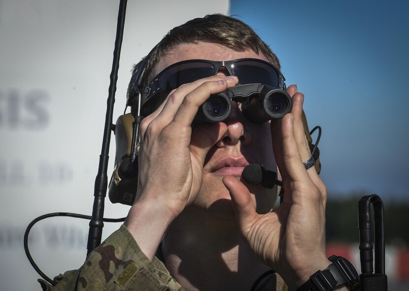 A combat controller with the 321st Special Tactics Squadron looks through binoculars before landing A-10 Thunderbolt IIs on Jägala-Käravete Highway, Aug. 10, in Jägala, Estonia. A small force of eight Special Tactics combat controllers from the 321st STS surveyed the two-lane highway, deconflicted airspace and exercised command and control on the ground and in the air to land A-10s from the Air National Guard's 104th Fighter Squadron on the highway. (U.S. Air Force photo by Senior Airman Ryan Conroy)