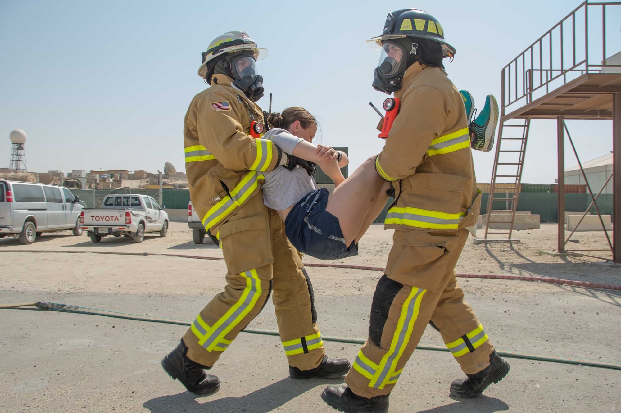 A team of firefighters perform a two-man carry during a victim extraction during a training scenario Friday, August 11, 2017, at the PERSCO building at an undisclosed location in Southwest Asia. (U.S. Air Force photo by 1st Lt. Rashard Coaxum)