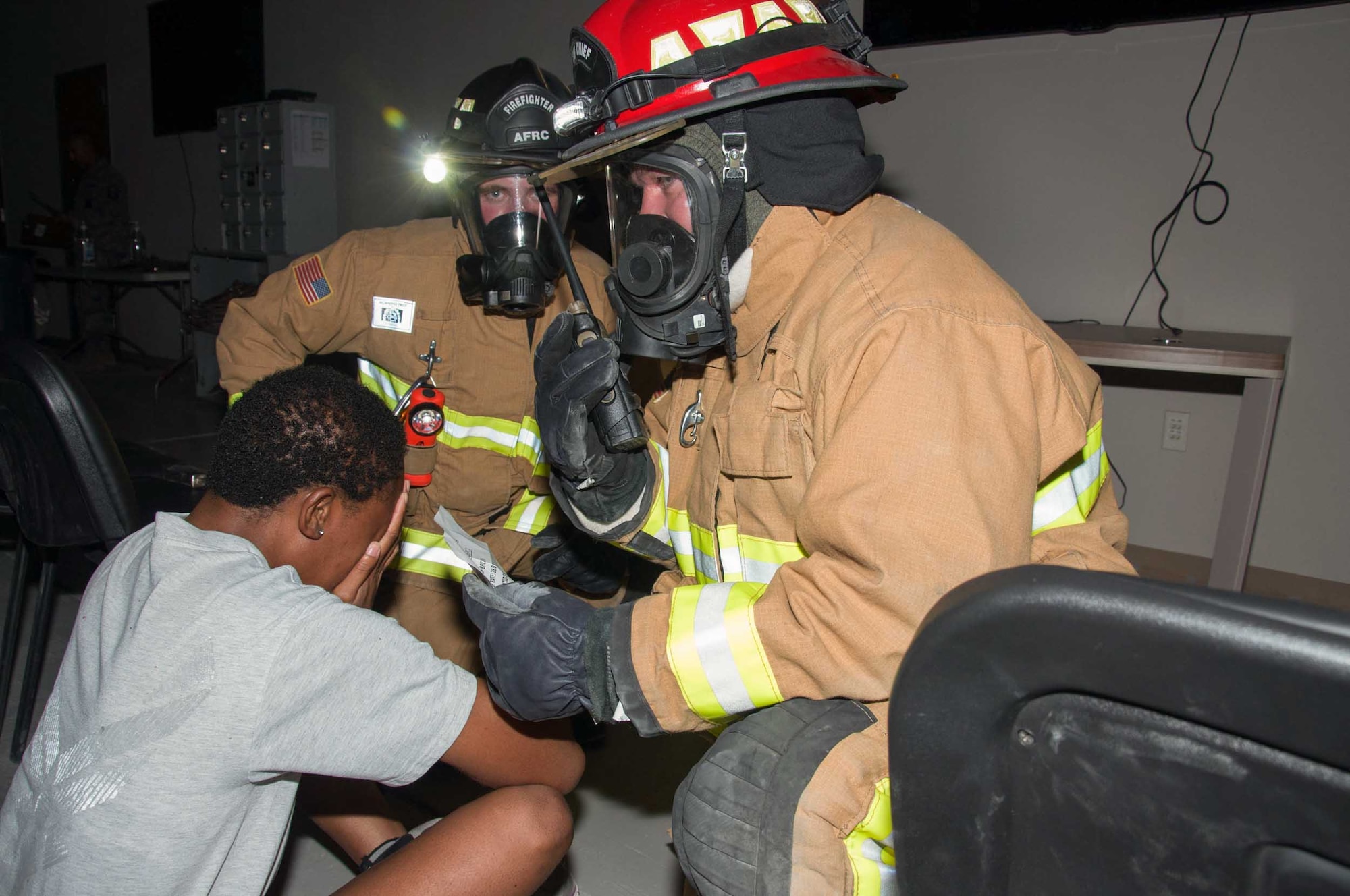 Two firefighters asess the condition of a simulated victim prior to extracting her from the building during a fire response exercise Friday, 11 August 2017, at an undisclosed location in Southwest Asia. (U.S. Air Force photo by Master Sgt. Eric M. Sharman)