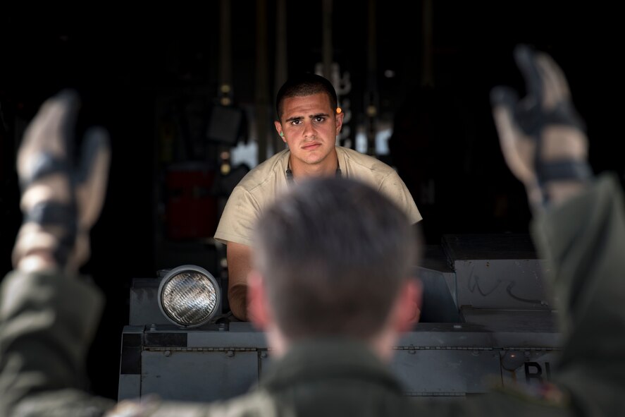 A weapons Airman from the 325th Fighter Wing looks toward a loadmaster from the 71st Rescue Squadron while loading equipment onto an HC-130J Combat King II, Aug. 9, 2017, at Tyndall Air Force Base, Fla. During Stealth Guardian, the 71st RQS worked alongside Airmen from the 325th Fighter Wing to provide airborne mission control and aerial refueling capabilities as well as forward area refueling and rearming points for the F-22 Raptor. (U.S. Air Force photo/ Staff Sgt. Ryan Callaghan)