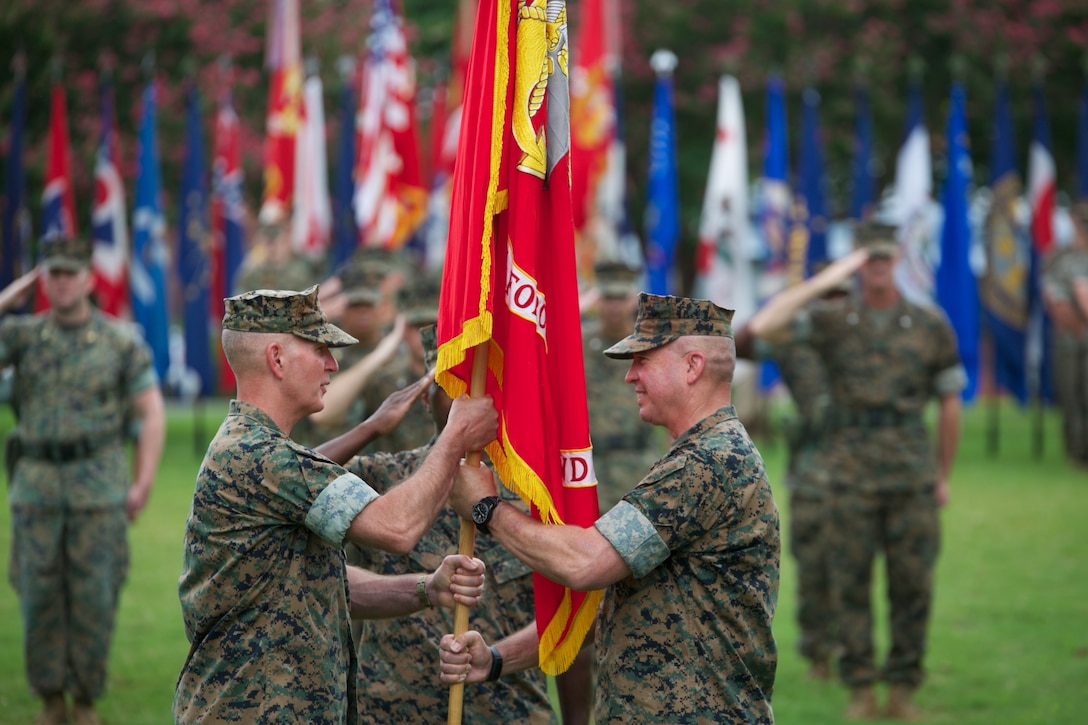 (Right to left) Lt. Gen.  John E. Wissler, Commander, U.S. Marine Corps Forces Command, passes the unit colors to Lt. Gen. Mark A. Brilakis during a change of command ceremony at POW/MIA Field aboard Naval Support Activity Hampton Roads, Aug. 14. Lt. Gen. Wissler assumed command of MARFORCOM in December 2015. Lt. Gen. Brilakis most recently served as the Deputy Commandant of Manpower and Reserve Affairs at Headquarters Marine Corps , Washington D.C.