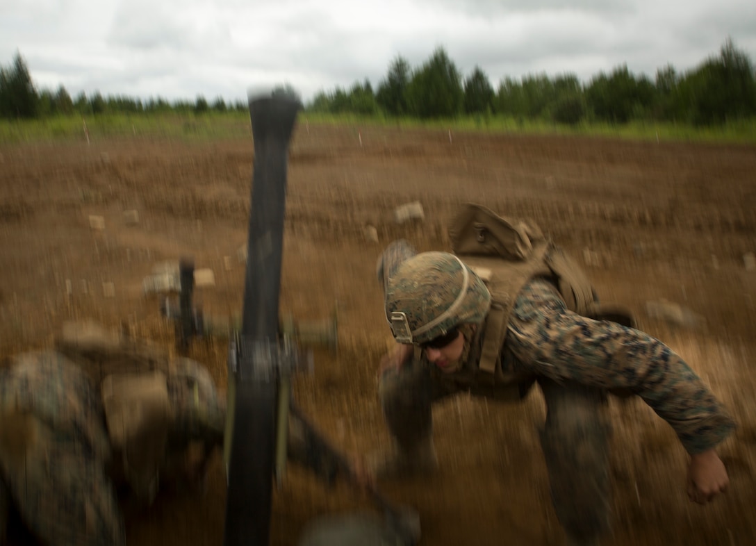Marine Corps Lance Cpl. Matthew Daily ducks after dropping a round into an M252 81 mm medium weight mortar system