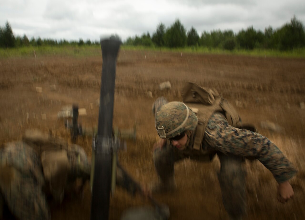 Marine Corps Lance Cpl. Matthew Daily ducks after dropping a round into an M252 81 mm medium weight mortar system