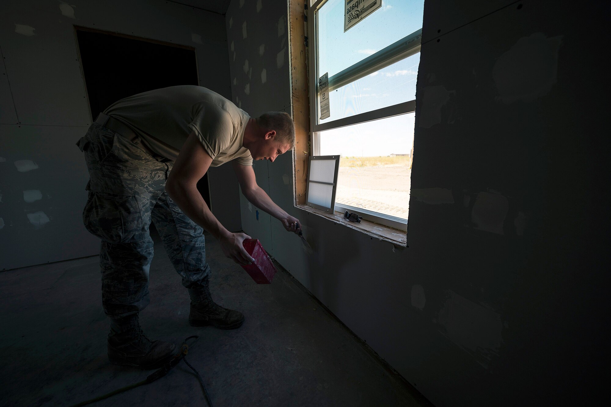 U.S. Air Force Senior Airman Drew Foes, an electrical power production specialist with the 182nd Civil Engineer Squadron, Illinois Air National Guard, applies drywall compound over screw heads in Crow Agency, Mont., July 27, 2017. The squadron helped build homes for Crow Nation veterans as part of the Department of Defense’s Innovative Readiness Training civil-military relations program. (U.S. Air National Guard photo by Tech. Sgt. Lealan Buehrer)