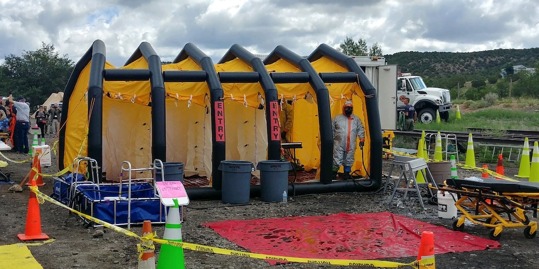 Soldier posing in portable decontamination shower.