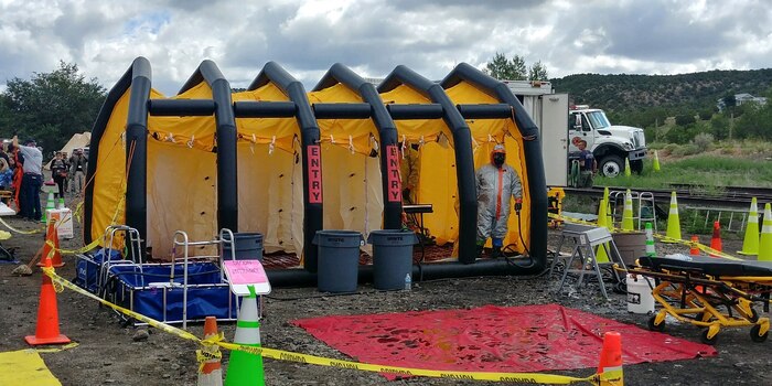 Soldier posing in portable decontamination shower.