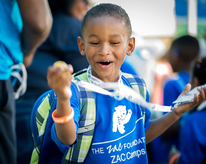 A ZAC Camp attendee holds his swim medal.