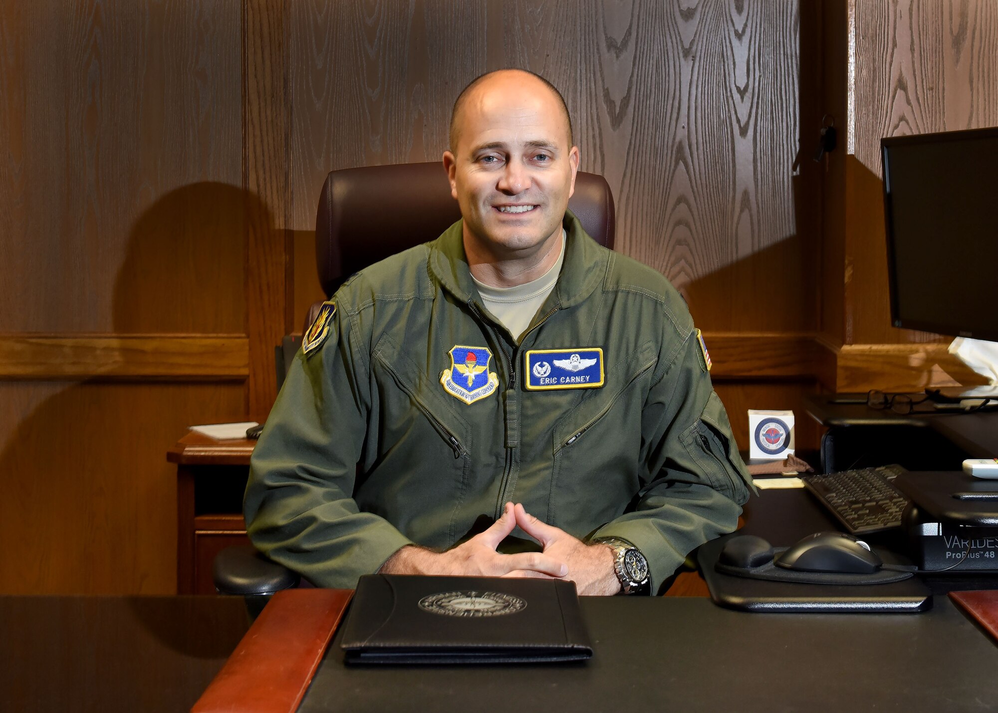 U.S. Air Force Col. Eric Carney, 97th Air Mobility Wing commander, poses at his desk, July 28, 2017, Altus Air Force Base, Oklahoma. Carney took command of the 97th AMW in June 2017 and wants to Airmen to concentrate on safety on and off the job and understanding the importance of each job. (U.S. Air Force photo by Senior Airman Nathan Clark/Released)