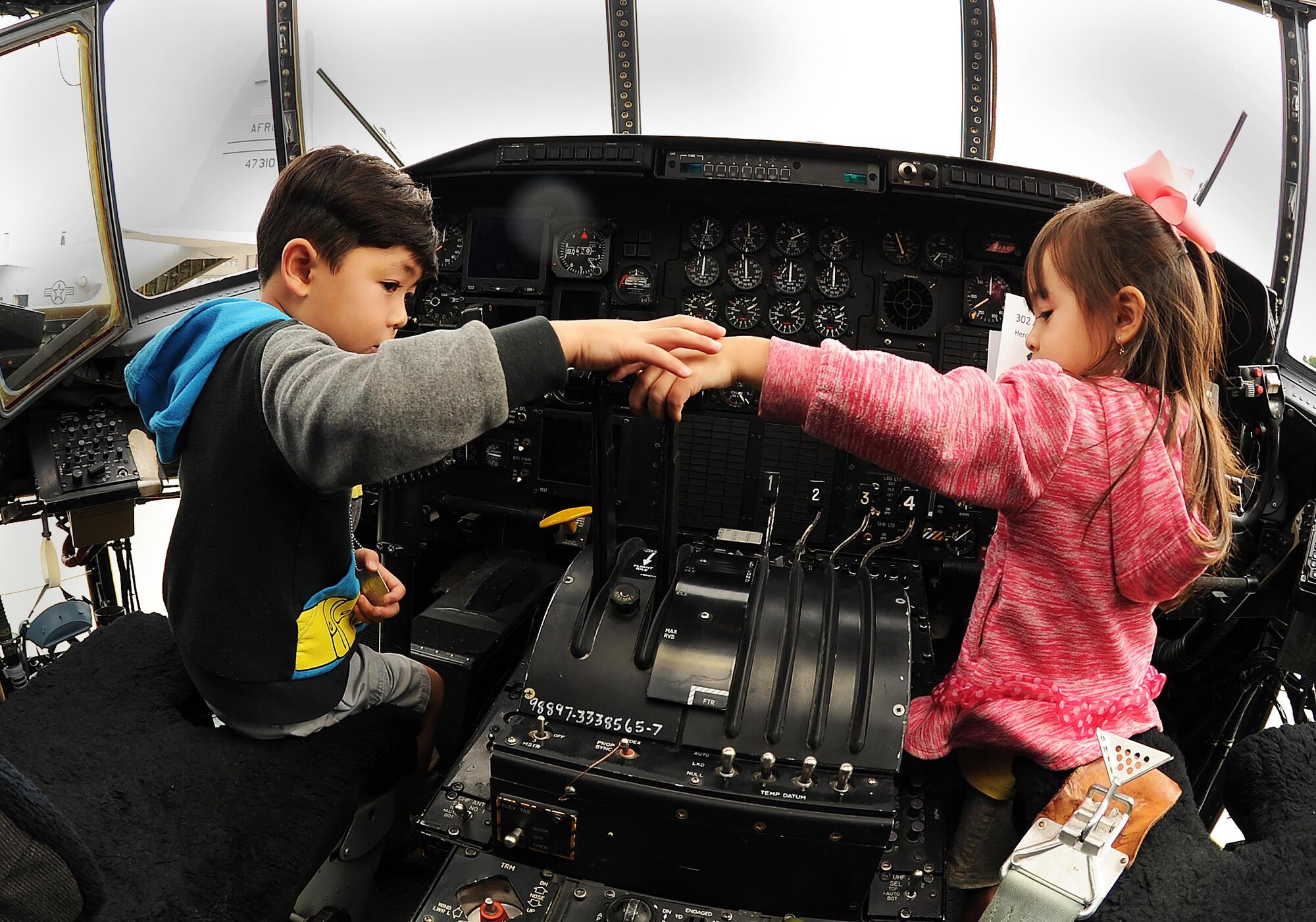 Children of Staff Sgt. Wanytha Mountry, 302nd Operations Group, Liam and Bristol, sit in the pilot and co-pilot seats on the flight deck of a C-130 Hercules aircraft during the annual 302nd Airlift Wing Family Day Herc Adventure Tour, Aug. 5, 2017, Peterson Air Force Base, Colo.