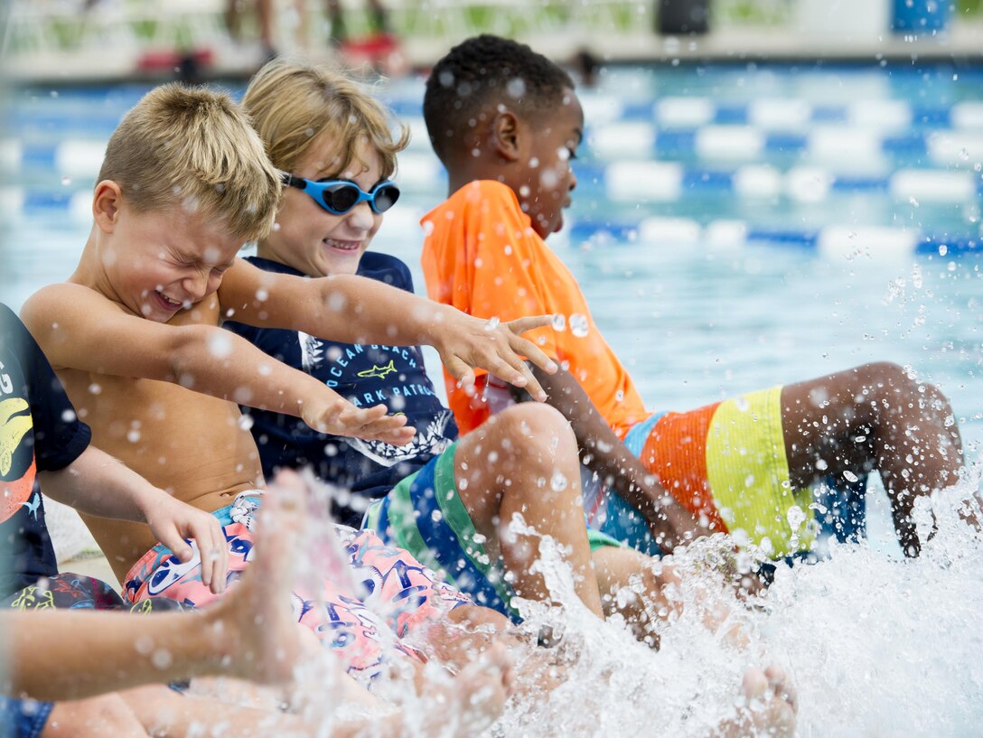 Children kick their feet in the base pool.