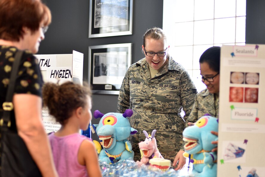 U.S Air Force Senior Airman Ariana Gordon, 17 Medical Operation Squadron dental assistant, demonstrates dental hygiene to a military family during Operation Back to School in the Event Center on Goodfellow Air Force Base, Texas, Aug. 10, 2017. The 17th Medical Group also provided child physicals at the clinic to ensure the children’s medical records are up to date. (U.S. Air Force photo by Airman 1st Class Randall Moose/Released)