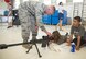 Senior Airman Levi Thompson, 37th Training Support Squadron combat arms instructor, shows Paige Borders how to adjust the scope on a sniper rifle during Operation Junior Expeditionary Team August 11, 2017 at Joint Base San Antonio-Lackland, Texas. Operation JET is an annual event that provides children of military services members a chance to experince the deployment process.  (U.S. Air Force photo by Benjamin Faske)