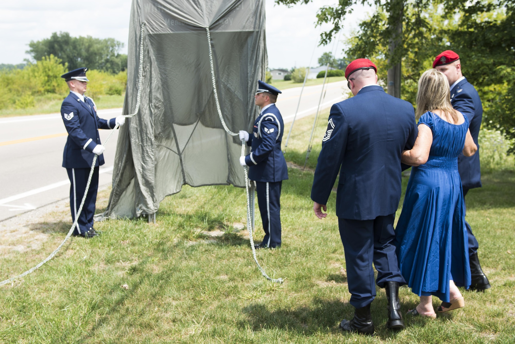 Senior Master Sgt. Bradford Greisen, 320th Special Tactics Squadron, and Col. Michael Martin, commander of the 24th Special Operations Wing, escort Sheila McDaniel to unveil a highway sign during a ceremony dedicating a six-mile stretch of Highway 121 in honor of her son, Master Sgt. William L. McDaniel II, in Greenville, Ohio, Aug. 14, 2017. McDaniel was part of a joint, special operations team who were infiltrating an island in Southern Philippines when the MH-47 Chinook helicopter he was in crashed into the Sulu Sea Feb. 22, 2002. (U.S. Air Force photo by Wesley Farnsworth)