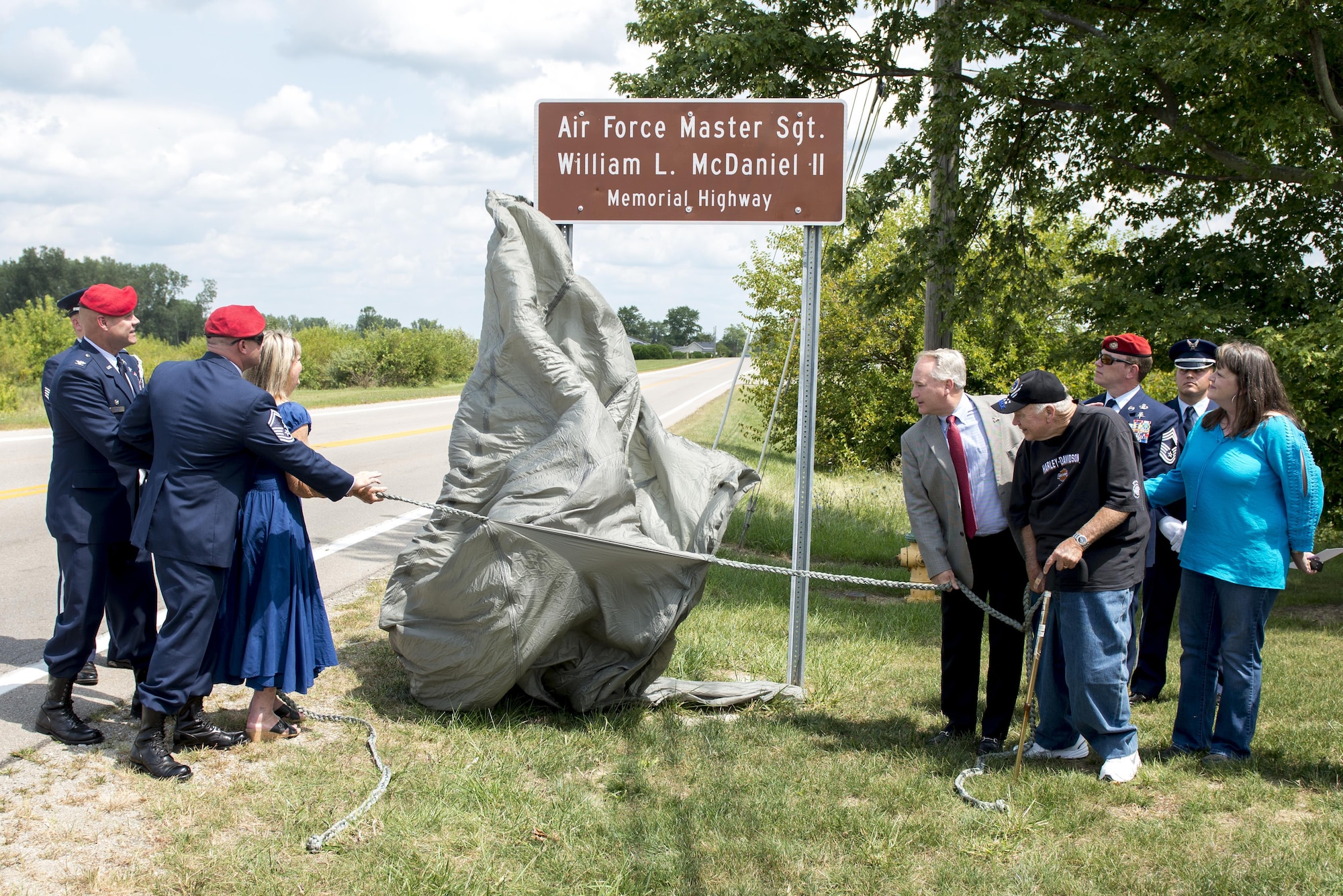 Family and friends of Master Sgt. William L. McDaniel II, unveil a highway sign during a ceremony dedicating a six-mile stretch of Highway 121 in honor of his namesake, in Greenville, Ohio, Aug. 14, 2017. McDaniel was part of a joint, special operations team who were infiltrating an island in Southern Philippines when the MH-47 Chinook helicopter he was in crashed into the Sulu Sea Feb. 22, 2002. (U.S. Air Force photo by Wesley Farnsworth)