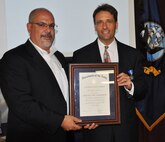 IMAGE: Naval Surface Warfare Center Dahlgren Division (NSWCDD) Technical Director John Fiore presents the Navy Superior Civilian Service Medal certificate to David Richardson, NSWCDD future combat systems engineer, at a ceremony held at the command's leadership forum. Richardson was honored for his, "numerous contributions to Navy programs and products through his remarkable management abilities, innovative thinking, and outstanding leadership."
