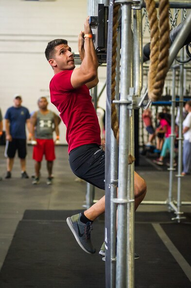 Senior Airman Jonathan Lane, 315th Airlift Wing Public Affairs,, tries out the Alpha Warrior Battle Rig’s "cliffhanger" obstacle during its introduction on the Globemaster Court at the Air Base Fitness and Sports Center on Joint Base Charleston, S.C., Aug. 5. (U.S. Air Force photo by Master Sgt. Shane Ellis)