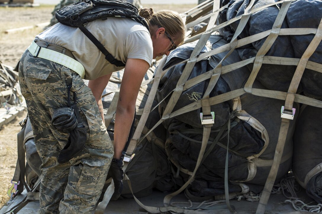 Air Force Senior Airman Kaila Mendez prepares cargo to be loaded on aircraft