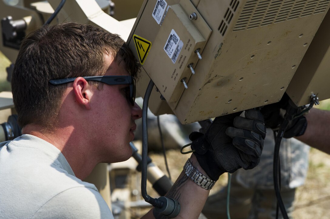Air Force Senior Airman Tyler Cook dismantles a small package initial communications element antenna.