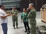 Barron Marcee, left, DLA Distribution Guam, Marianas, site manager, discusses the cargo layout in the Materiel Processing Center.