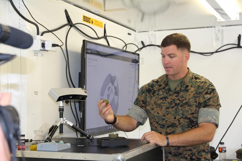 Sgt. Ethan Maeder, a machinist with the 2nd Maintenance Battalion at Camp Lejeune, North Carolina, demonstrates how to use a 3-D scanner in the X-FAB Facility Aug. 1. The X-FAB, or Expeditionary Fabrication, Facility is a self-contained, transportable additive manufacturing lab comprised of a 20-by-20-foot shelter, 3-D printers, a scanner and computer-aided design software system that can be used to fabricate repair and replacement parts in the field. The Marine Corps is exploring this expeditionary capability to expedite heavy equipment repairs in deployed environments. (U.S. Marine Corps photo by Kaitlin Kelly)