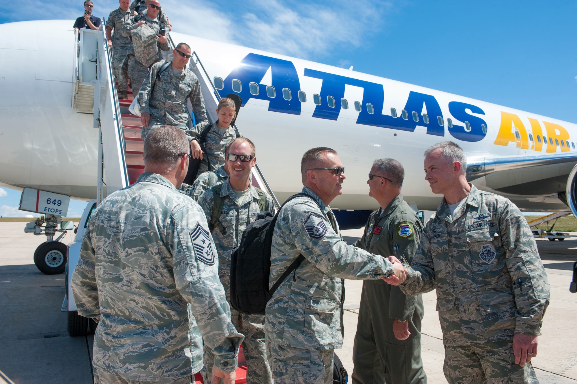 Commanders greeting Airmen as they come off airliner