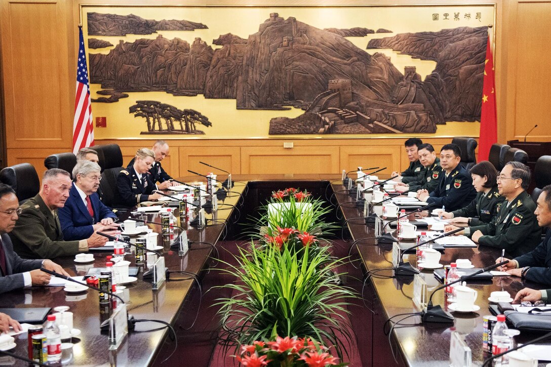 U.s. and Chinese military leaders sit around a table.