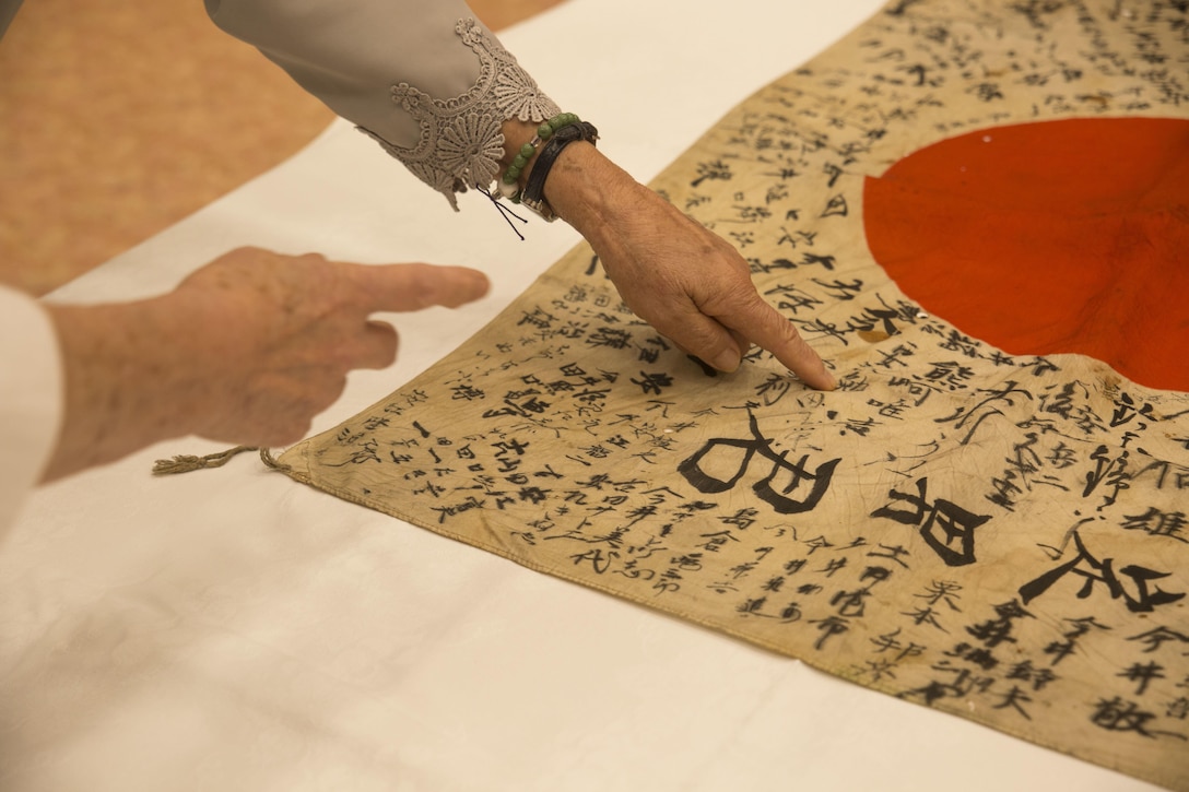 Villagers point out family names on Sadao Yaasue’s flag at Higashishirakawa Village, Gifu Prefecture, Japan, Aug. 15, 2017. World War II veteran Marvin Strombo traveled 10,000 miles from his quiet home in Montana to personally deliver a flag he had taken from the Japanese soldier during the battle of Saipan. The heirloom was given to Yasue before he departed to the war from his family and village members. It was adorned with the signatures of all his loved ones as a symbol of good fortune. The flag is the only thing the Yasue family has been able to retrieve since their brother departed 73 years ago. The reunion was made possible by the Obon Society of Astoria, Oregon. The ceremony also took place during the Obon holiday in Japan. A holiday dedicated to going back to the place of origin of one’s family and spending time with one another.