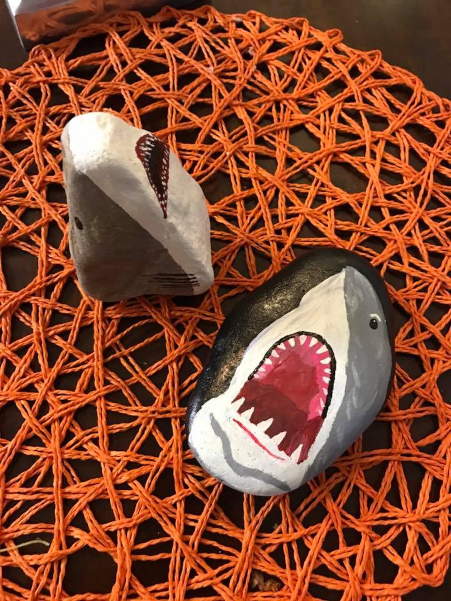 Vanessa Legaspi Henneman finishes painting shark rocks and then hid them on Peterson Air Force Base, Colo., Aug. 4. 2017. The group will often pick a theme for the week and paint rocks in that theme. The theme for the week of July 31, was based on TV’s shark week. (Courtesy photo by Vanessa Legaspi Henneman)
