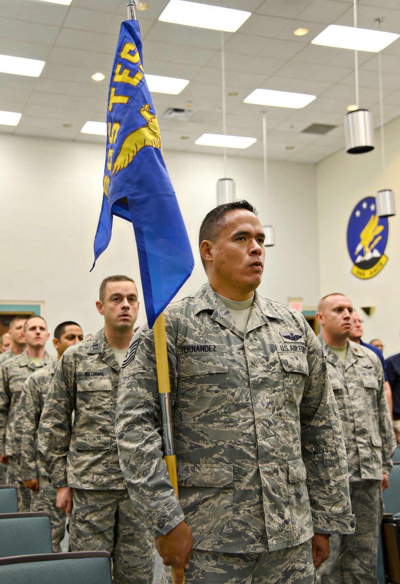 Tech. Sgt. Kamanu Fernandez, test flight engineer and additional duty first sergeant, holds the newly unfurled guidon for the 605th Test and Evaluation Squadron, Detachment 1, while in formation with his squadron during a ceremony Aug. 7, 2017, in Fannin Hall.